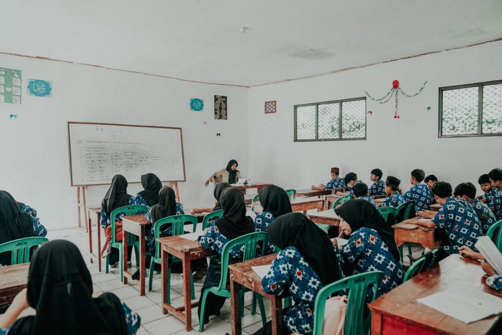 Guru dan siswa berhijab dalam suasana kelas pembelajaran aktif
