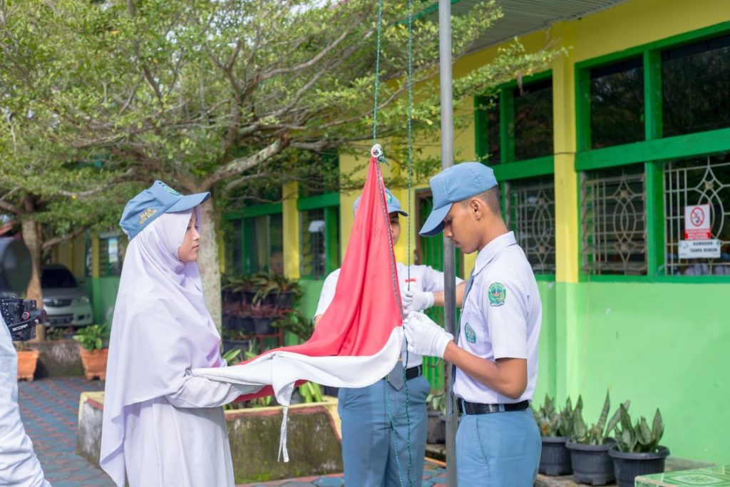 Siswi berhijab mengikuti upacara pengibaran bendera merah putih